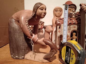 Statua di donna accovacciata in terracotta