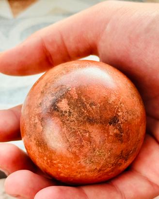 Dorodango rosso con striature nere lucidato a mano