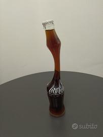 Bottiglia Coca Cola vintage con collo allungato.
