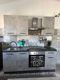 Cucina completa, tavolo, sedie e parete attrezzata