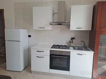 cucina completa di frigorifero e camera da letto