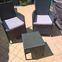 Poltrone con cuscini e tavolino da giardino