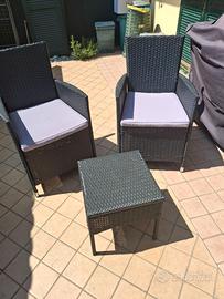 Poltrone con cuscini e tavolino da giardino