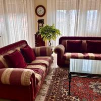 Divani classici bordeaux in velluto e tessuto.