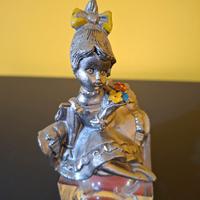 Bambola in peltro cesellato