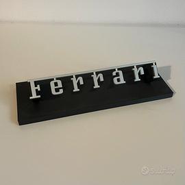 Scritta Ferrari con supporto da esposizione