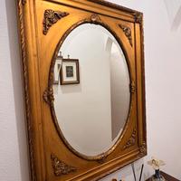 Specchio ovale con cornice dorata intagliata