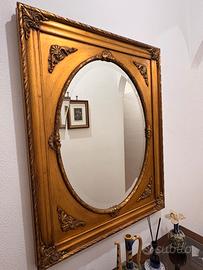 Specchio ovale con cornice dorata intagliata