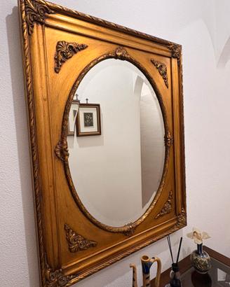 Specchio ovale con cornice dorata intagliata