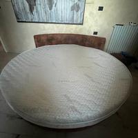 Grande letto matrimoniale rotondo con pouf e sedia