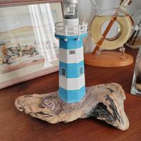 Faro decorativo su legno di mare