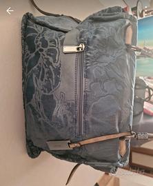 Borsa di velluto blu con motivi floreali.