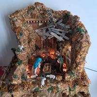 Presepe fatto a mano con pastori e luci.