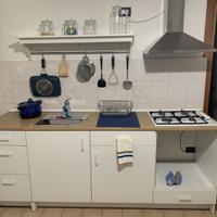Cucina, bianca, con lavello, piano cottura e cappa