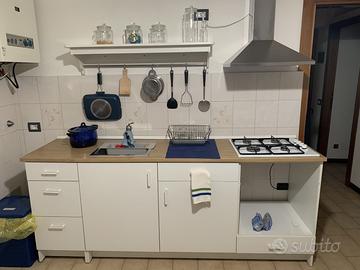 Cucina, bianca, con lavello, piano cottura e cappa