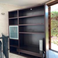 Libreria in legno scuro con vano in vetro