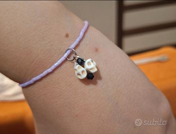 Bracciale artigianale lilla con ciondoli teschi e 