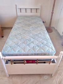 Letto singolo con rete e materasso.
