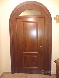 Porta in legno ad arco con bugne e vetro superiore