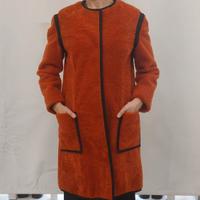 Cappotto in montone bouclè tinto arancione.