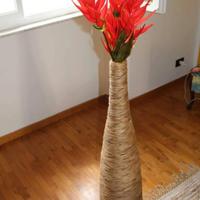 vaso lungo di vimini con fiori finti rossi