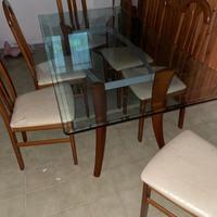 Tavolo in vetro con gambe in legno e sedie