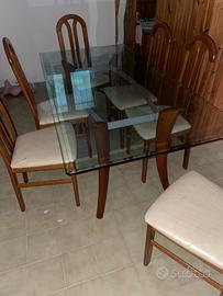 Tavolo in vetro con gambe in legno e sedie