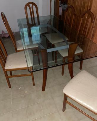 Tavolo in vetro con gambe in legno e sedie