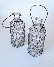 Coppia di bottiglie in vetro con rete in ferro