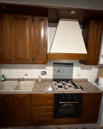 Cucina in legno con piano in granito e forno