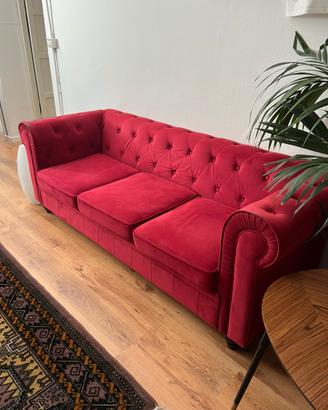 Divano rosso in velluto stile chesterfield