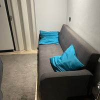 divano-letto con cuscini e puff contenitore