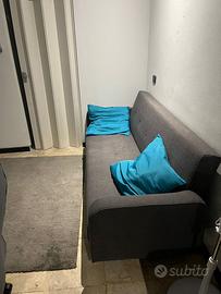 divano-letto con cuscini e puff contenitore