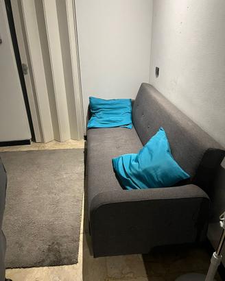 divano-letto con cuscini e puff contenitore