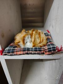 Gatto peluche realistico addormentato su cuscino