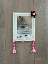 Cornice in legno con stella in tricotin e nappe.