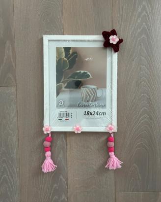 Cornice in legno con stella in tricotin e nappe.
