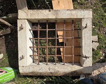 contorno finestra in pietra con inferriata