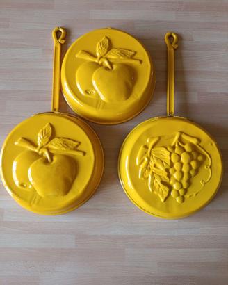 Stampi vintage in metallo smaltato giallo.
