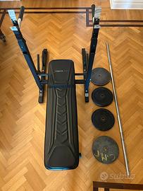 Panca da palestra con bilanciere e pesi