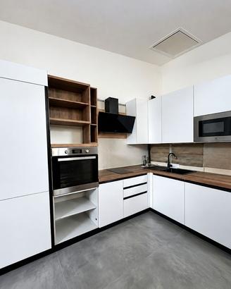 Cucina ad angolo bianca attrezzata con elettrodome