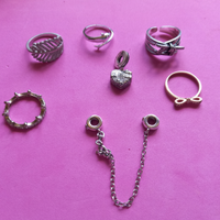 Lotto 5 anelli + 2 charms simil nota marca