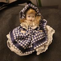 Bambola in porcellana con vestito a quadri 