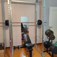 Power rack completo di bilancieri, panca e pesi.