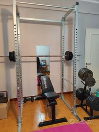 Power rack completo di bilancieri, panca e pesi.