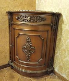 Angoliera in legno con decorazioni in rilievo.