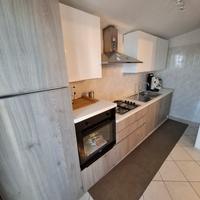 Cucina con elettrodomestici e tavolo living