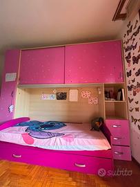 una cameretta di colore rosa con un letto singolo