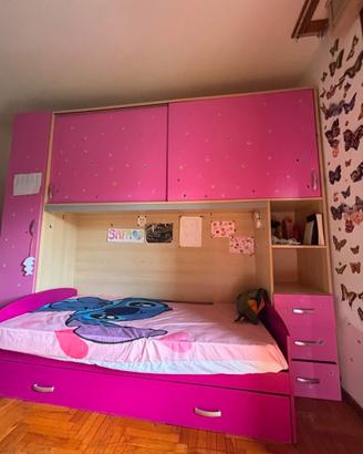 una cameretta di colore rosa con un letto singolo