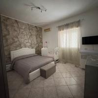 Cucina, camera da letto, divano, tavolo e sedie.